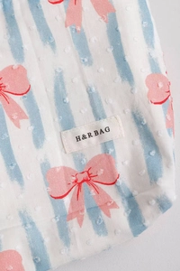 Dettaglio della trousse con trama a pois svizzeri e motivi di fiocchi rosa