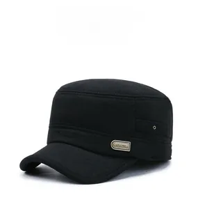 Detail of winter flat cap showing black fabric texture and rectangular metal brand plate