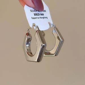 Detailed macro view of silver 925 hexagonal chunky hoop earrings with polished finish