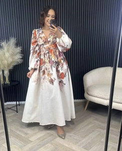 Detail of floral printed maxi dress featuring a high waist and long sleeves in ivory