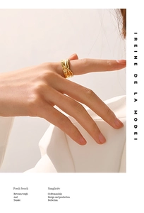 Detail of irregular textured gold plated ring on finger with elegant minimalist aesthetic