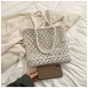 Detail of white handmade woven tote bag with hollow mesh design for beach vacation