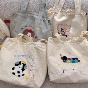 Detail of cute embroidered puppy and cat patterns on large canvas shoulder bags