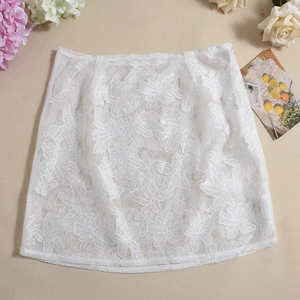 Detailed view of white floral lace skirt fabric texture with delicate mesh patterns