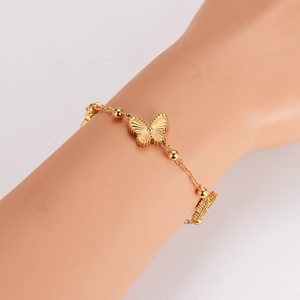 Bracelet papillon doré poli sur main de mannequin avec chaîne à billes fine et gravure
