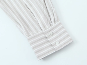 Detailed macro view of striped poplin shirt cuff featuring two white buttons