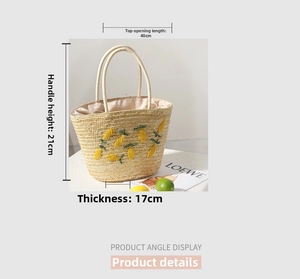 Detailed close-up of handmade straw tote bag with vibrant lemon embroidery for beach