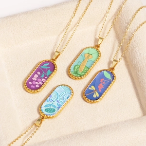 Detailed macro view of four vintage oval pendants with botanical patterns on a beige tray