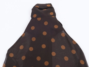 Detailed view of dark brown polka dot chiffon top with a high-neck halter design