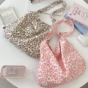 Detail of canvas tote bags with heart leopard print pattern in beige and pink styles