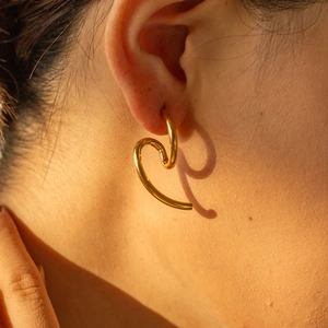 Close-up of elegant 18k gold plated stainless steel heart earrings worn by a model
