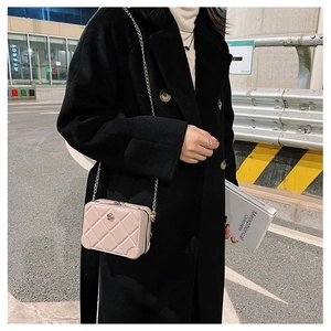 Chic beige quilted PVC jelly bag with gold chain strap in a stylish street setting