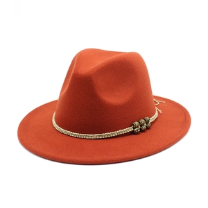 Close-up of burnt orange wool fedora with a woven band and metallic bead details