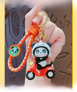 Detail of cartoon panda biker keychain with woven strap and metallic lobster clasp