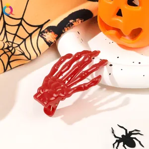Macro shot of a red skeleton hand hair clip with spooky Halloween pumpkin decorations