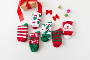 Detail of six Christmas coral fleece socks with festive patterns and soft fuzzy texture