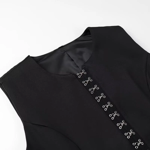 Detail of silver metal hook closures on a black sleeveless top with delicate texture