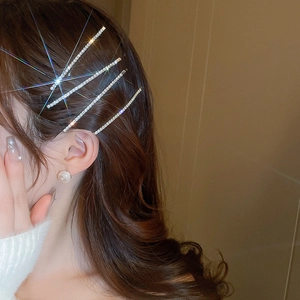 Detail of model wearing four sparkling silver rhinestone hair clips in a side hair style