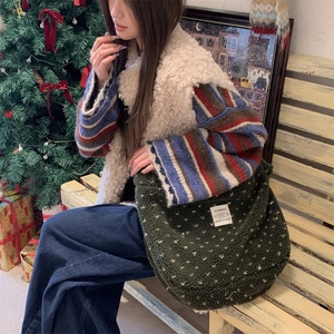Detail of green plush tote bag with white polka dots in a warm festive setting