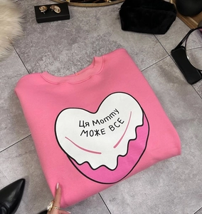 Gros plan sur l'imprimé cœur rose et le lettrage cyrillique sur le sweat chaud