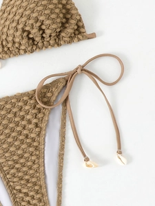 Detail of coffee brown textured bikini fabric with tie side and shell pendant detail