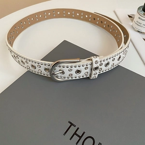 Detailed macro view of white leather belt featuring silver studs and sparkling rhinestones