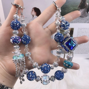 Macro detail of luxury blue beaded phone strap with rhinestone crystals and silver rings