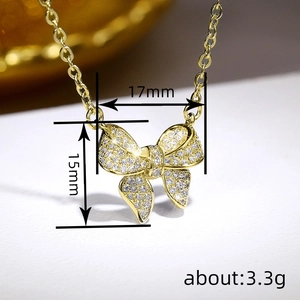 Macro shot of gold bow pendant with micro-pave cubic zirconia and size dimensions