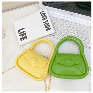 Mini jelly chain handbags in yellow and green displayed with lifestyle props
