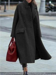 Street style view of a long charcoal wool coat with double-breasted buttons and lapels