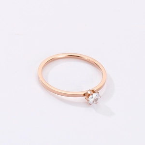 Close-up of a minimalist rose gold honeycomb ring with a single sparkling clear gemstone