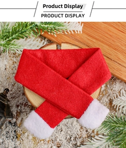 Detailed view of red Christmas mini scarf with white pompoms on wooden base
