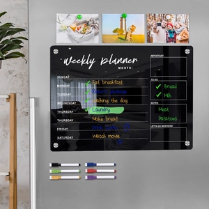 Close-up of black glass weekly magnetic calendar board with six colored marker pens