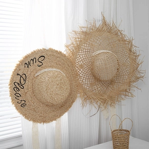 Detailed texture of raffia sun hats with lace ribbons and fringed edges for beach decor