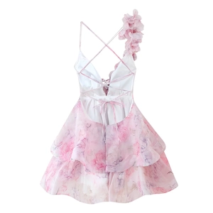 Détail de robe en mousseline fleurie rose avec bretelles croisées et fleur sur l'épaule