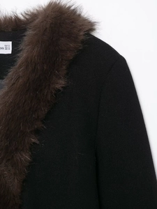 Detail shot of the plush faux fur collar on a black winter coat with a size label