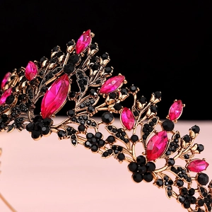 Macro detail of gothic gold tiara featuring ruby crystals and black rhinestones