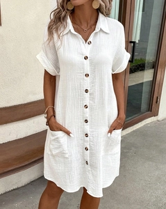 Detail of white V-neck cotton linen shirt dress with functional buttons and front pockets