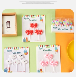 Close-up of cute cartoon party candles including red bow and smiling cloud shapes