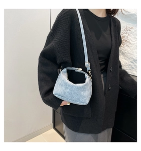 Detail view of the light blue textured leather crossbody bag with silver hardware
