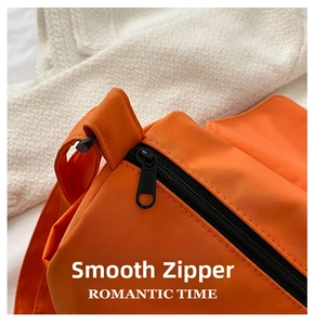 Detail of smooth black metal zipper on bright orange oxford fabric messenger bag