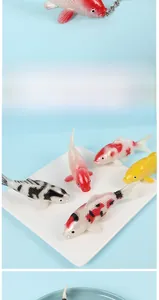 Detailed view of realistic PVC koi carp pendants with metallic chains and scales