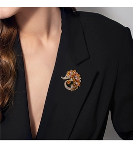 Detailed close-up of a hedgehog brooch with colorful crystals on a black blazer