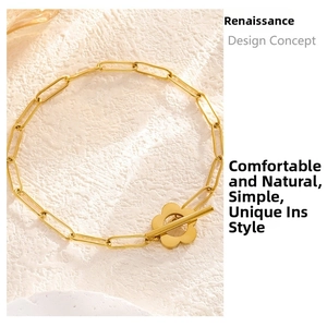 Detail of gold paperclip chain bracelet featuring a unique plum blossom OT toggle clasp