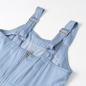Dettaglio della fibbia in metallo regolabile e della cerniera sull'abito di jeans blu