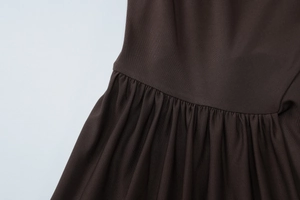 Macro-opname van donkerbruine twillstof met gedetailleerde plooien en elegante rimpeling