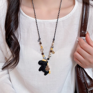Detail of beaded necklace featuring a black horse leather pendant and colored beads