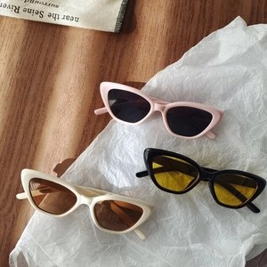 Three pairs of vintage cat-eye sunglasses for kids in pink, black, and white frames