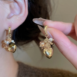 Detail of heart drop earrings with champagne crystal beads and small pearls in gold
