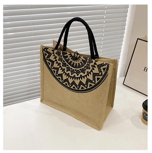 Detail of bohemian jute tote bag with black geometric patterns and round handles